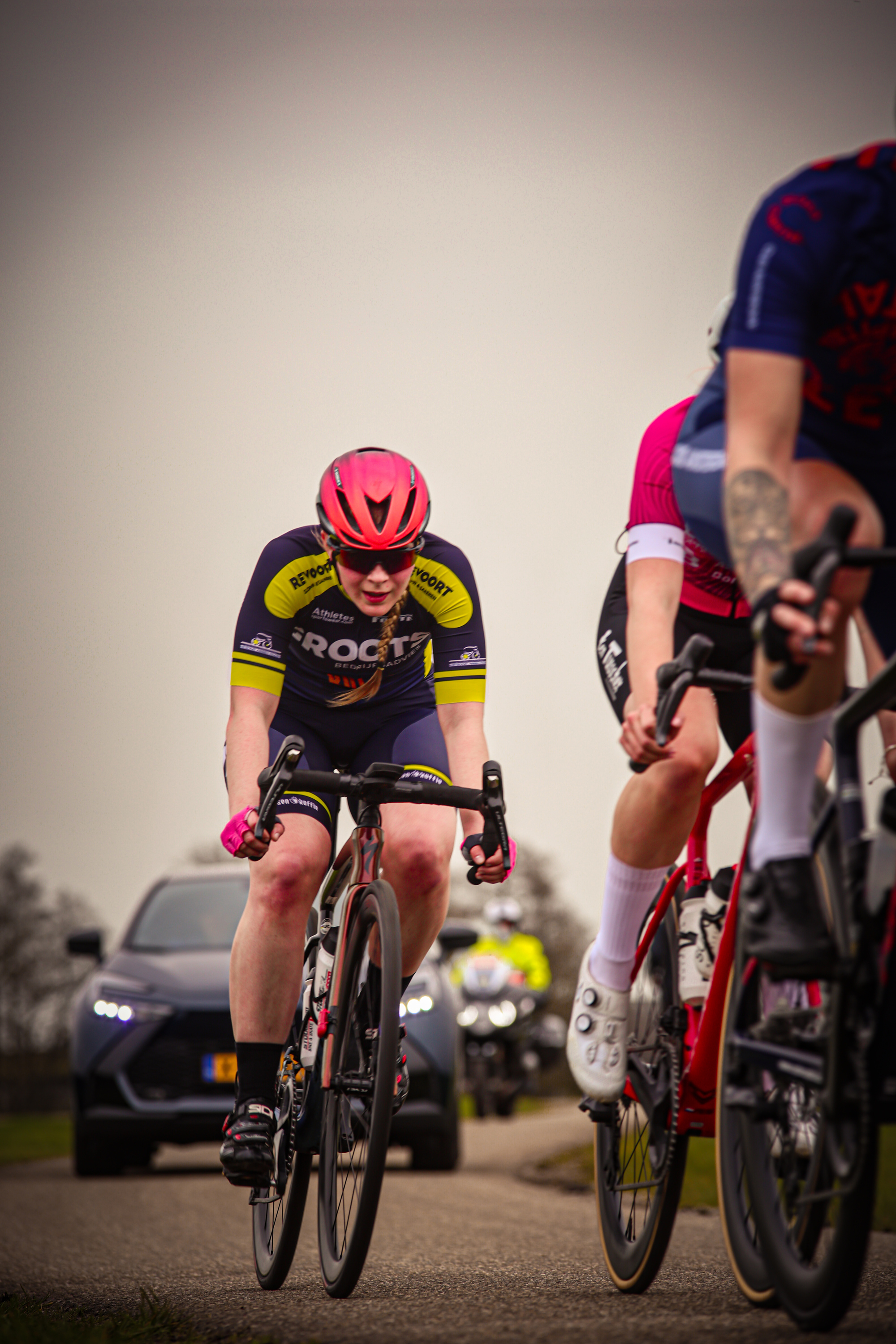 Two bicyclists race through a countryside village.