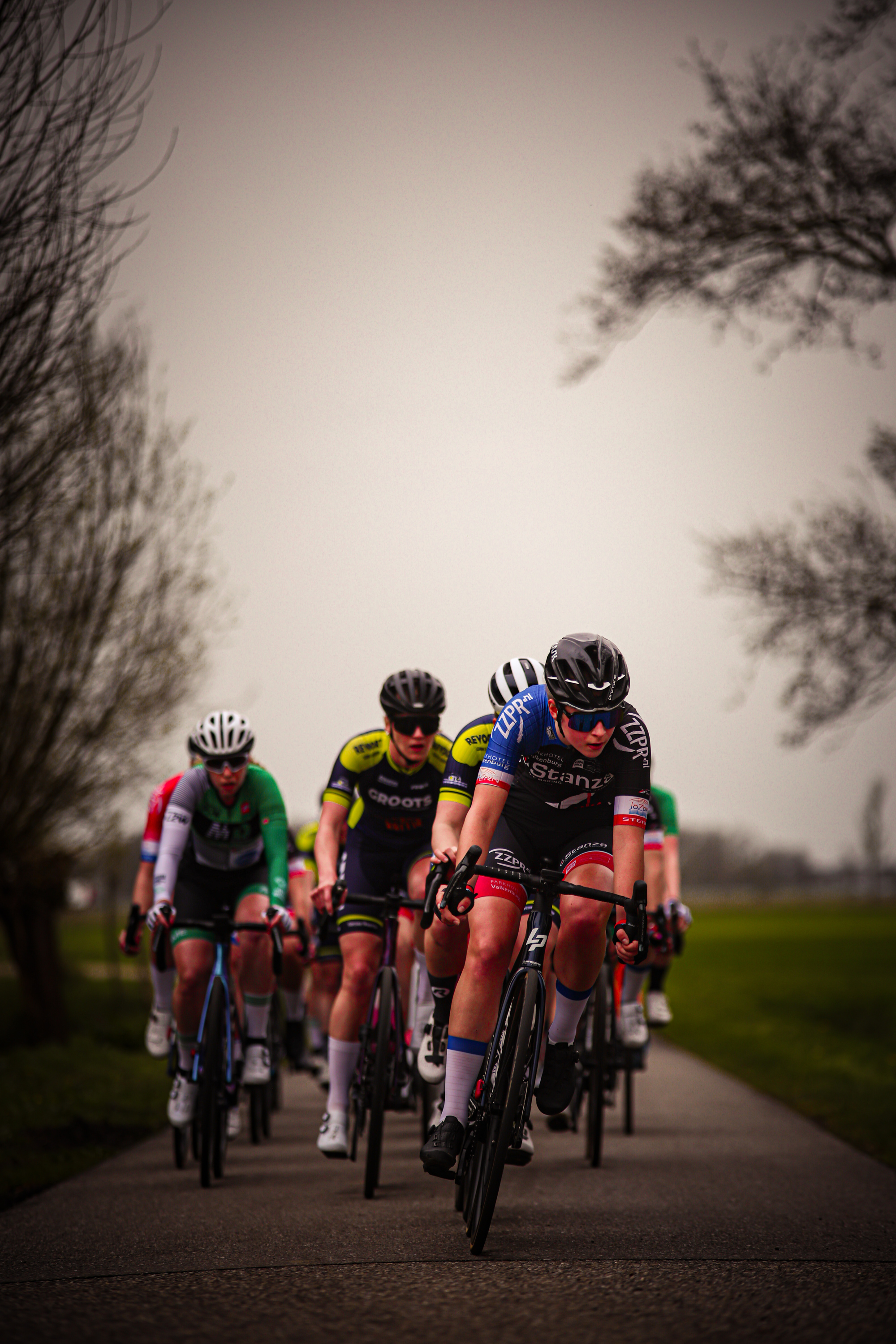 A group of cyclists are riding on a road in the Netherlands.