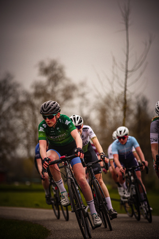 Three cyclists are riding together on a road during the Ronde van de Lichtmis race.