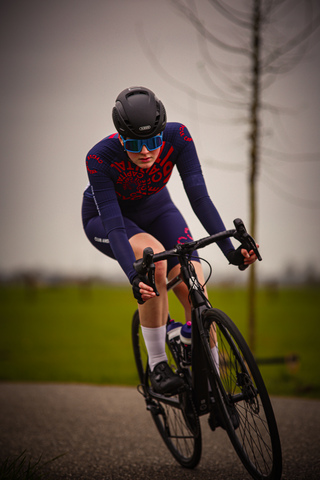 A woman in a bike race, number 24 is on her black helmet.