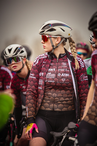 A group of cyclists wearing red and black Adidas shirts and helmets.