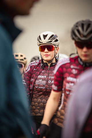 A person wearing a red and white jersey with the text "Ronde van de Lichtmis" is wearing sunglasses.