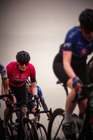 A group of cyclists in motion with a backdrop of a city.