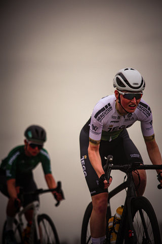 Two men in cycling uniforms on their bikes in the middle of a race.