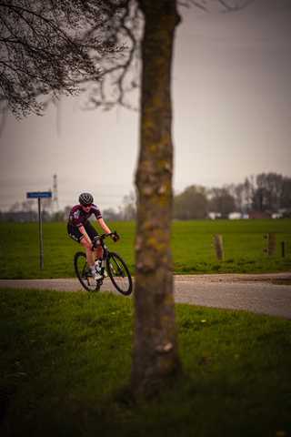 A cyclist wears number 15 and rides down a dirt road.