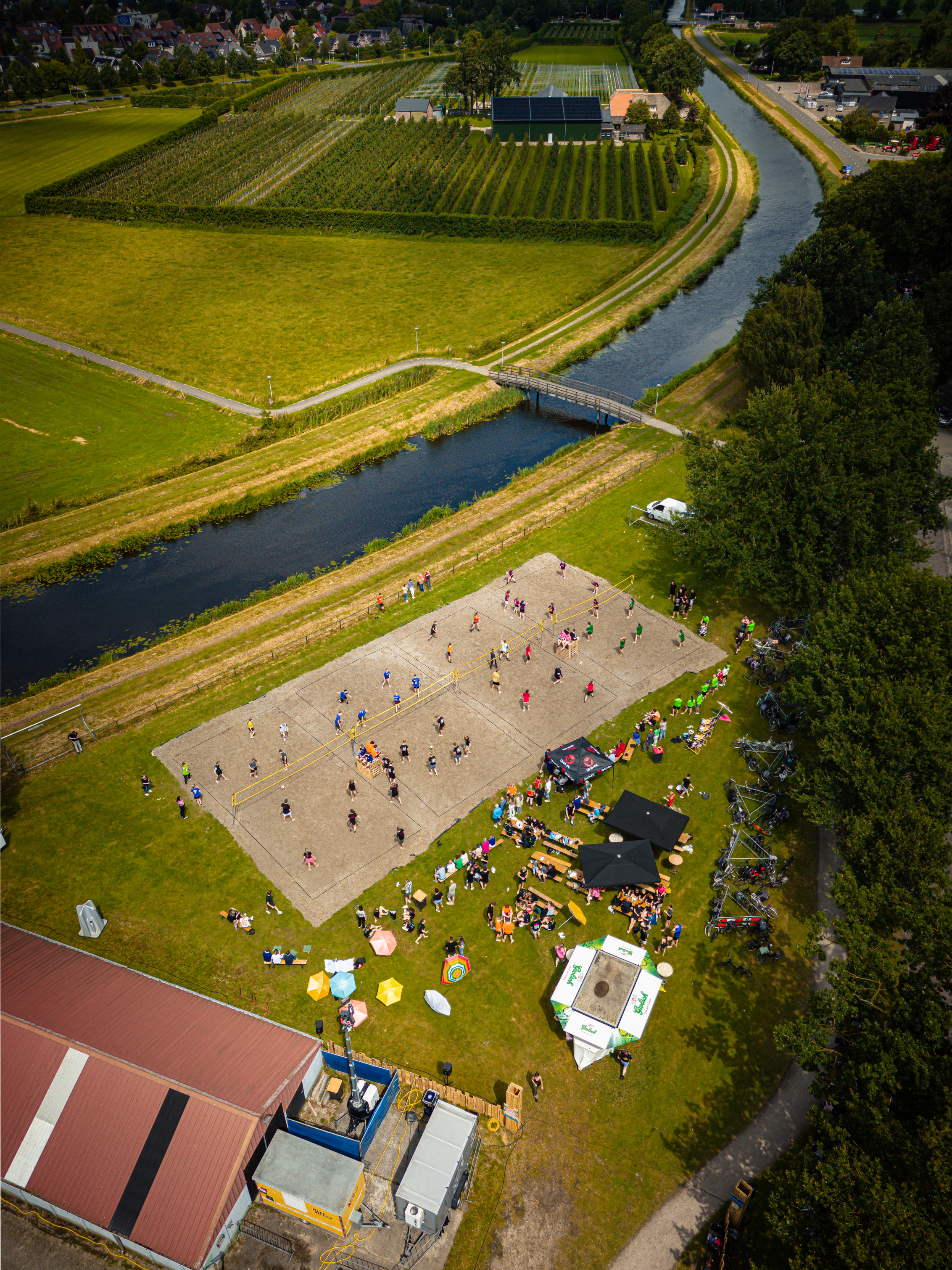 A group of people are playing beach volleyball outside on a grassy field.