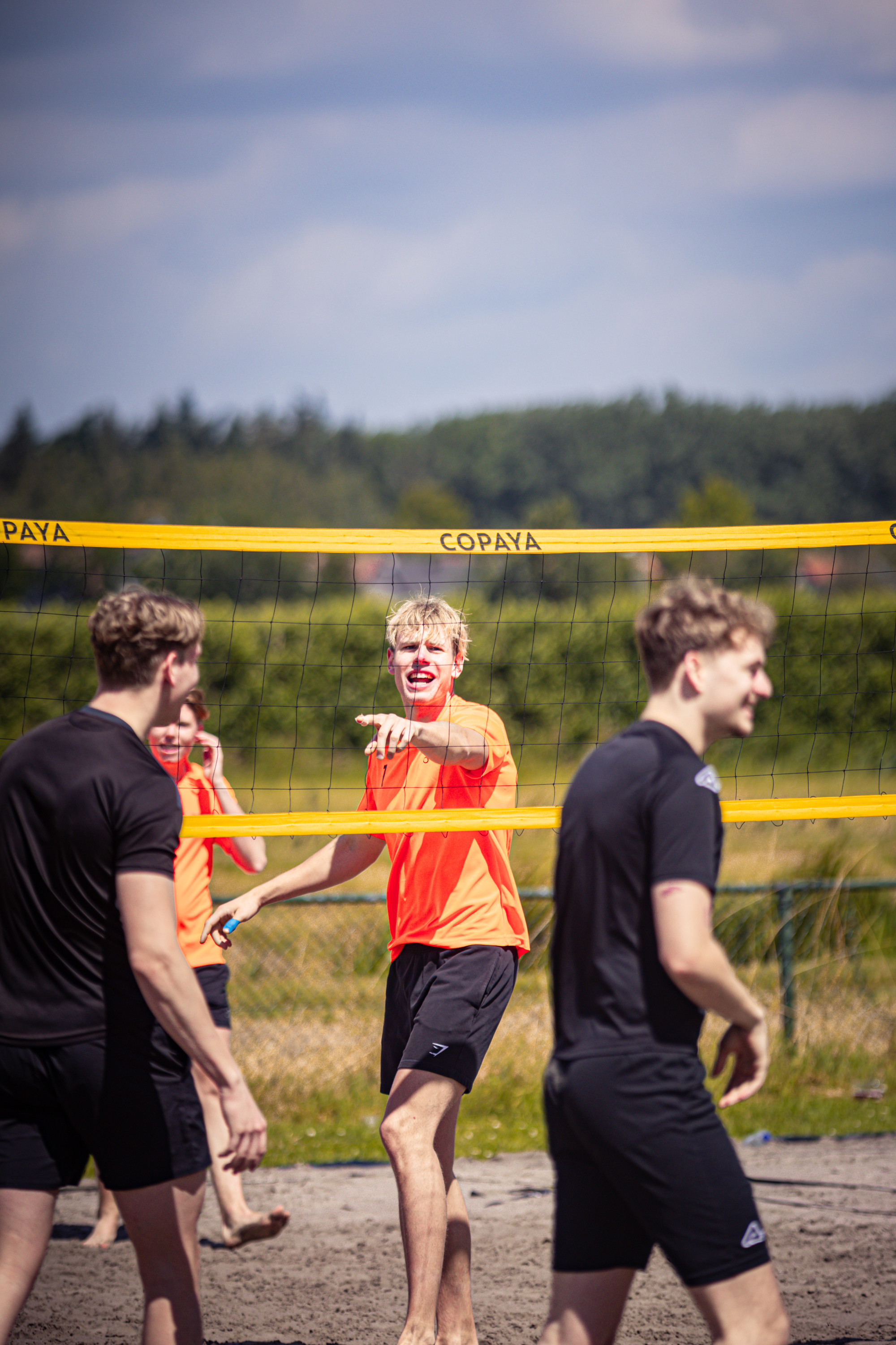 A group of people playing a game of beach volleyball.