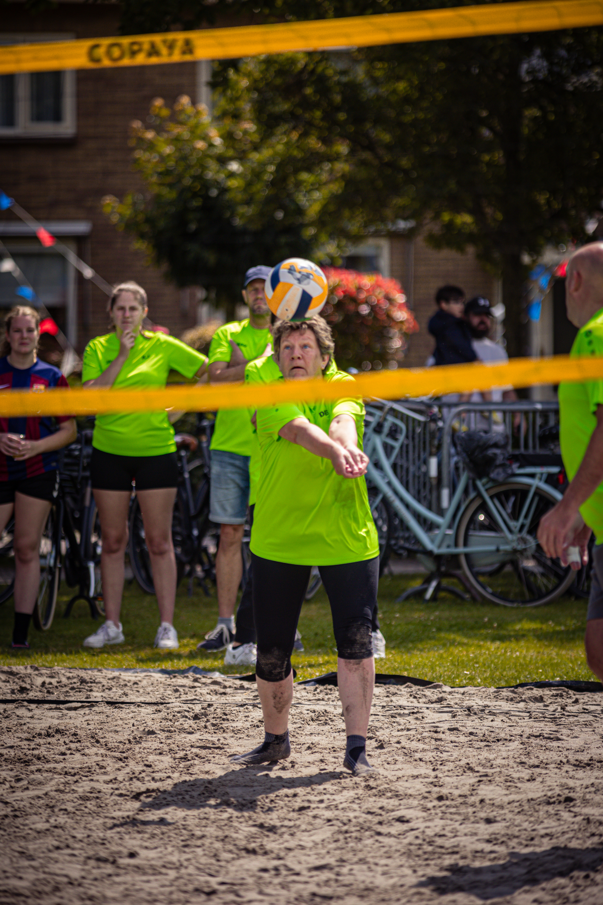 A young man is about to hit a volleyball in a beach volleyball game.