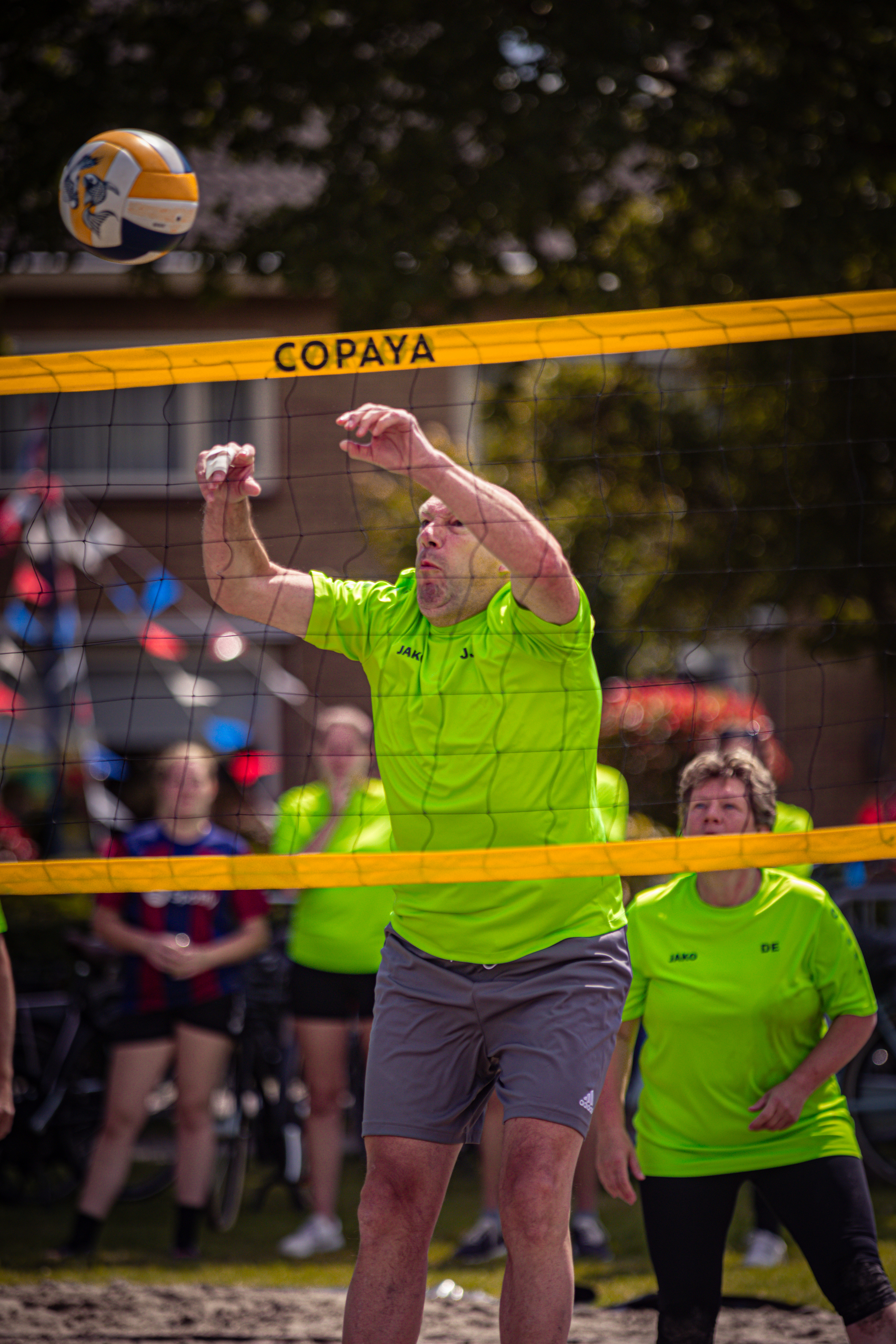 Volleyball game being played in a green shirt with the word COPAYA on it.