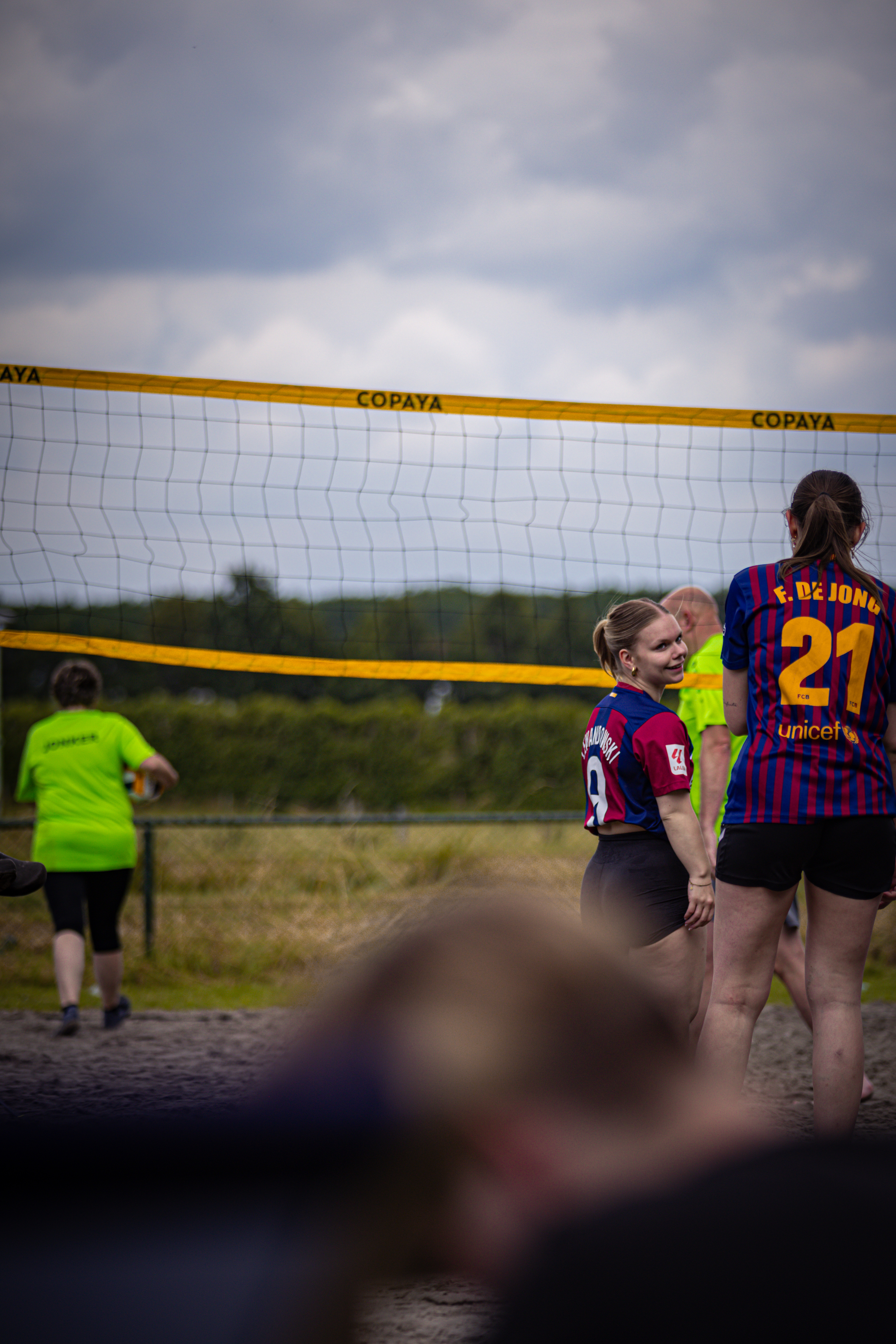 Two women are playing beach volleyball in front of a crowd.