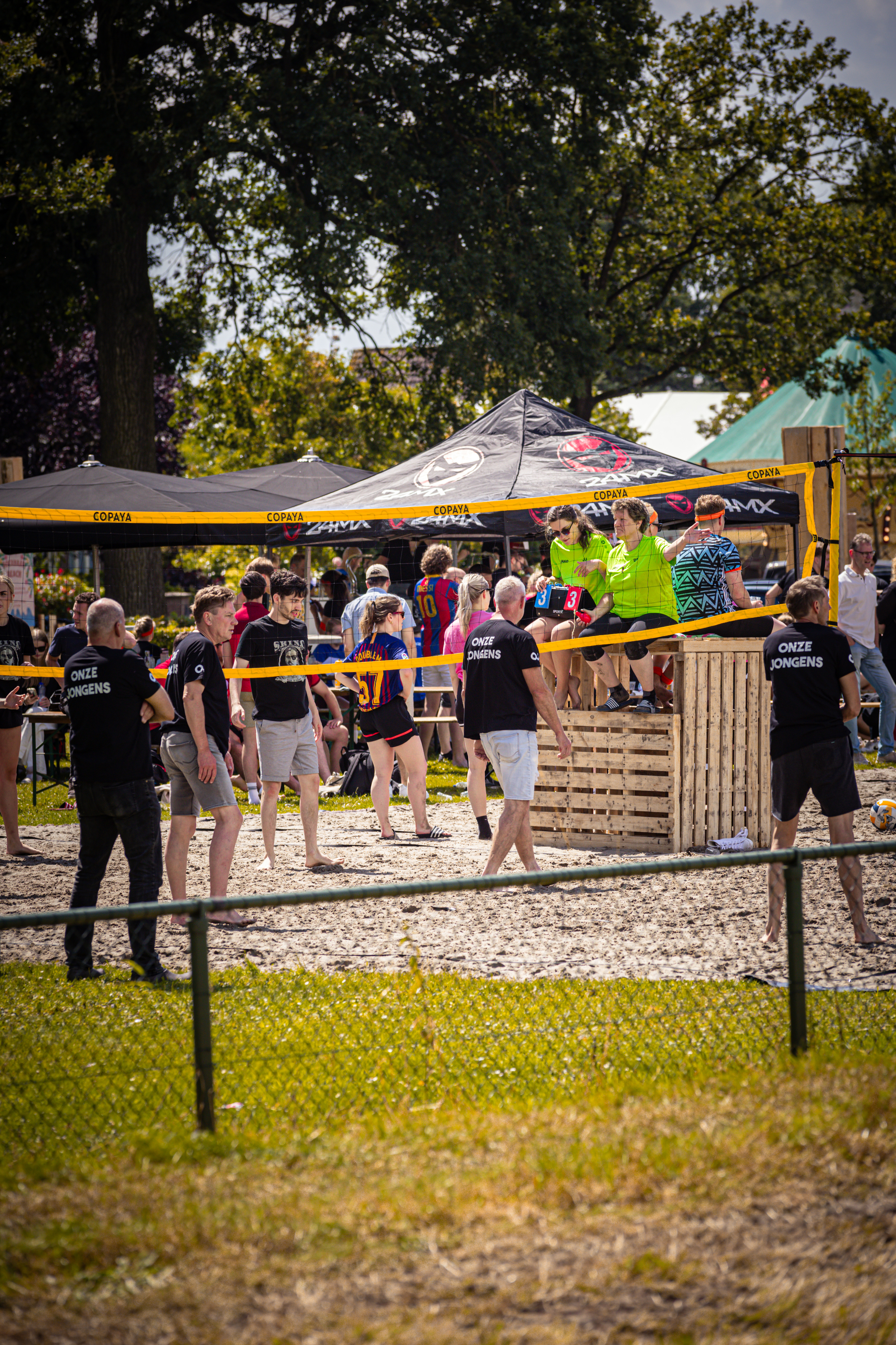 A group of people are enjoying a beach volleyball game.