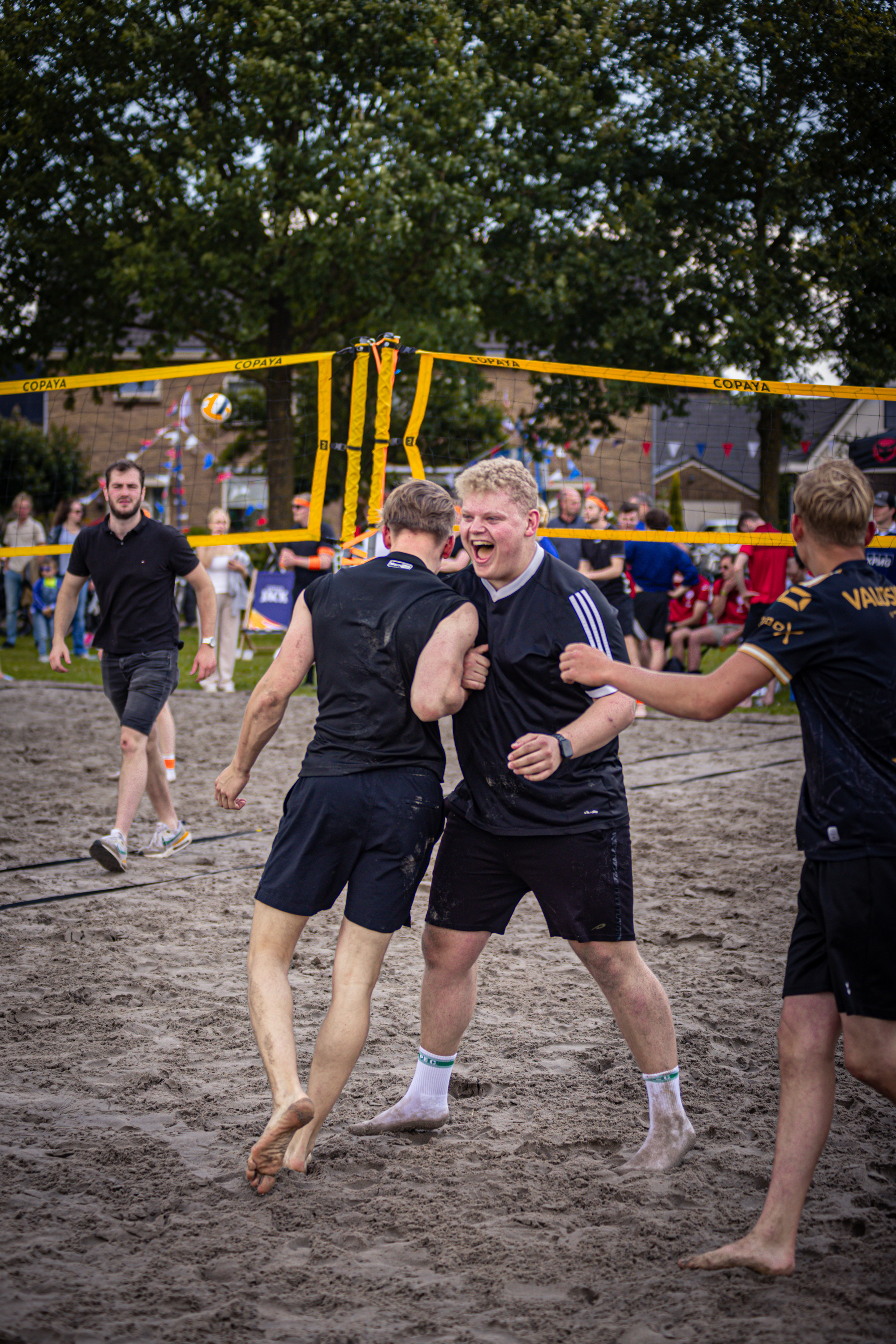 A group of people playing volleyball on the beach.