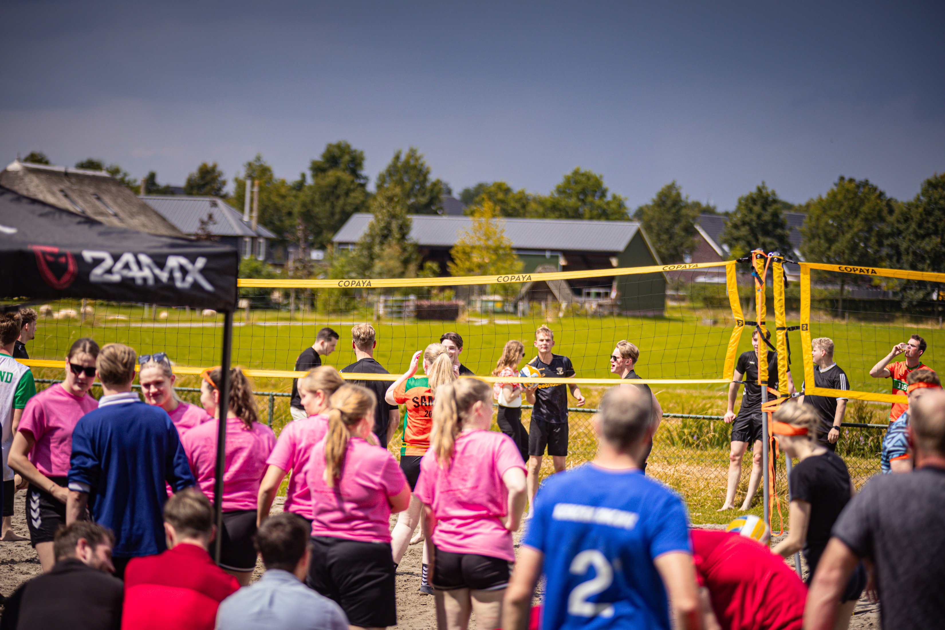 A lively group of people participating in a beach volleyball game.