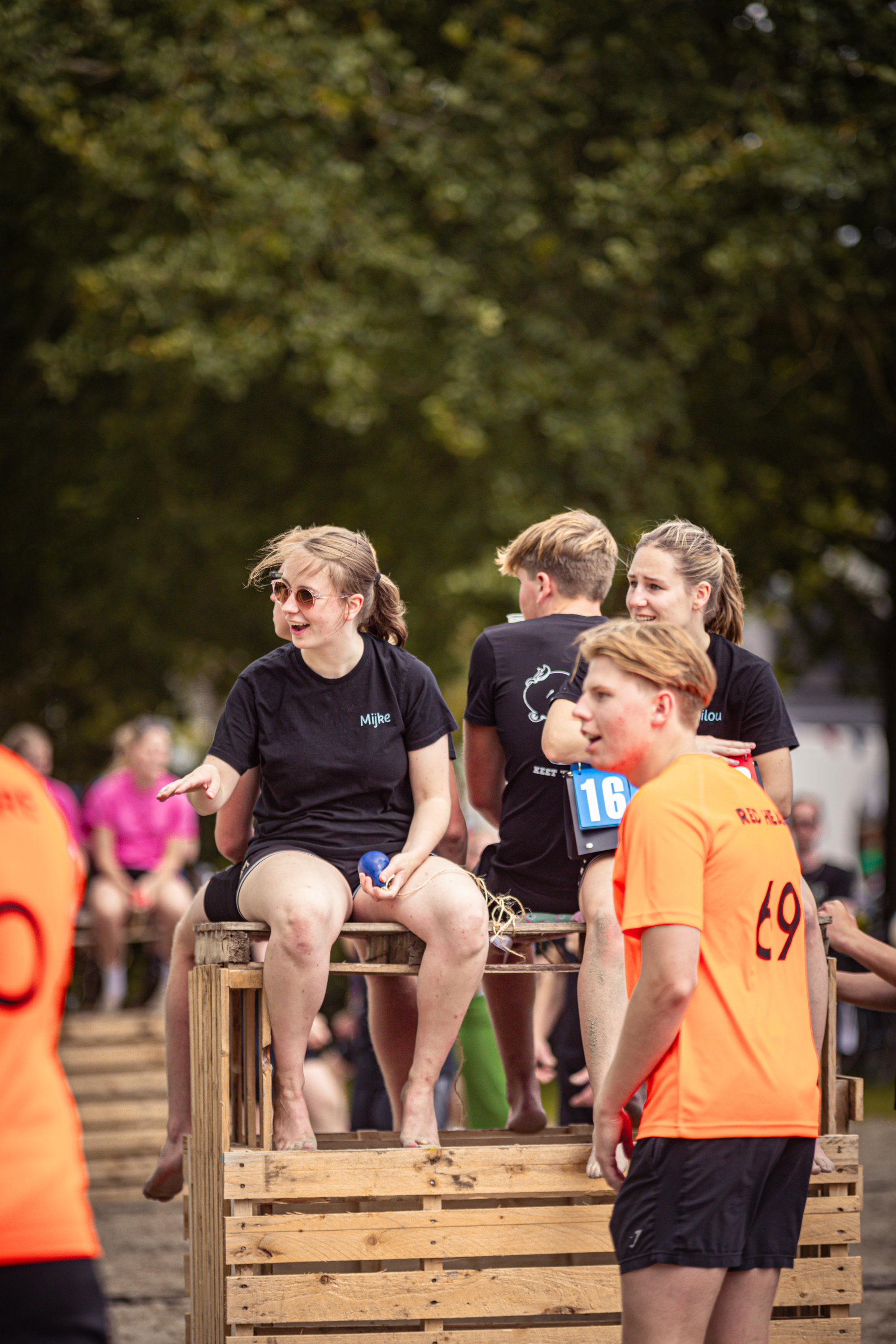 A group of people watching a beach volleyball game in the Netherlands.