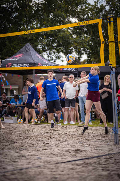 A group of people are playing beach volleyball at Kermis Boerhaar.