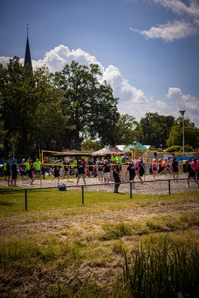 A group of people are playing a game of beach volleyball.