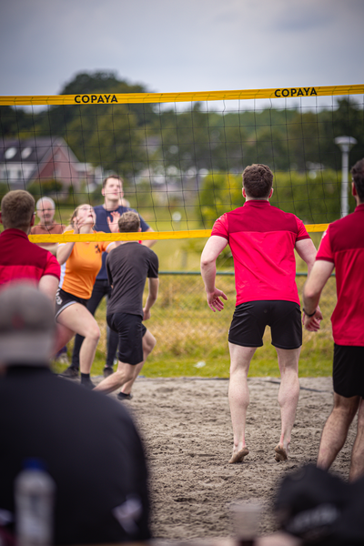 A group of people are playing a game of beach volleyball.