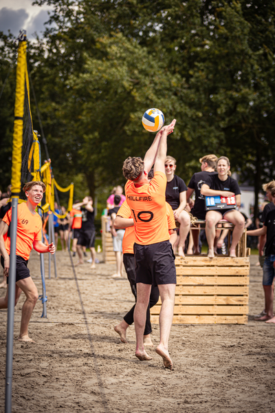 Beach Volleybal game where a player is jumping to hit the ball.