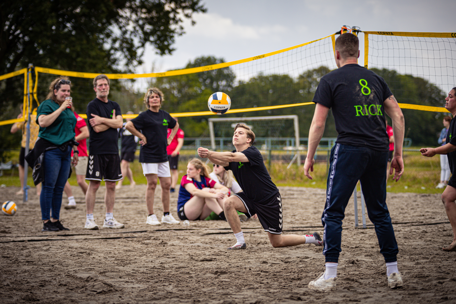 People playing beach volleyball with a man in black and white jersey on the right, who says "Rich 8".