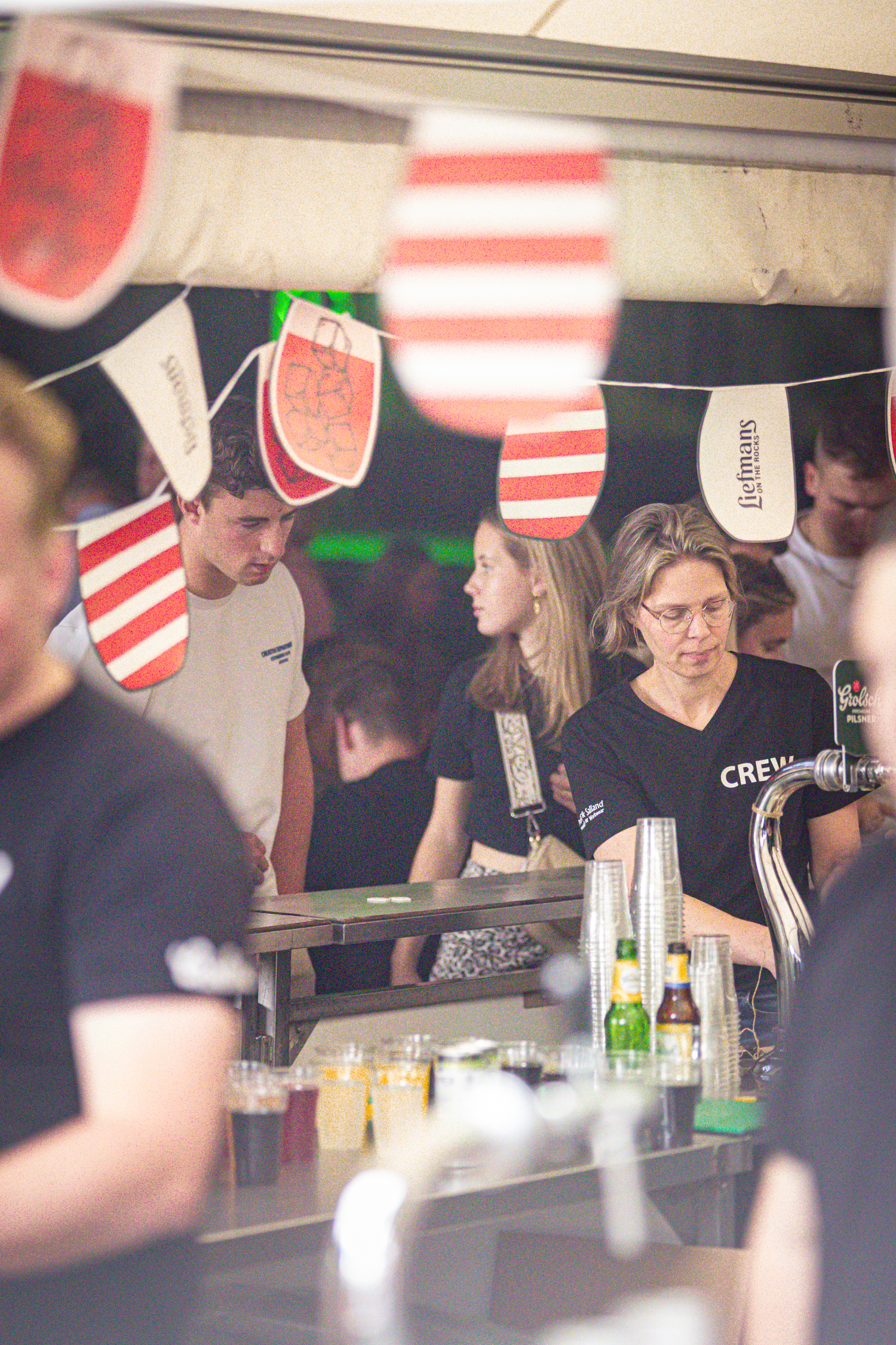 People are gathered around a table at an event where drinks can be enjoyed.