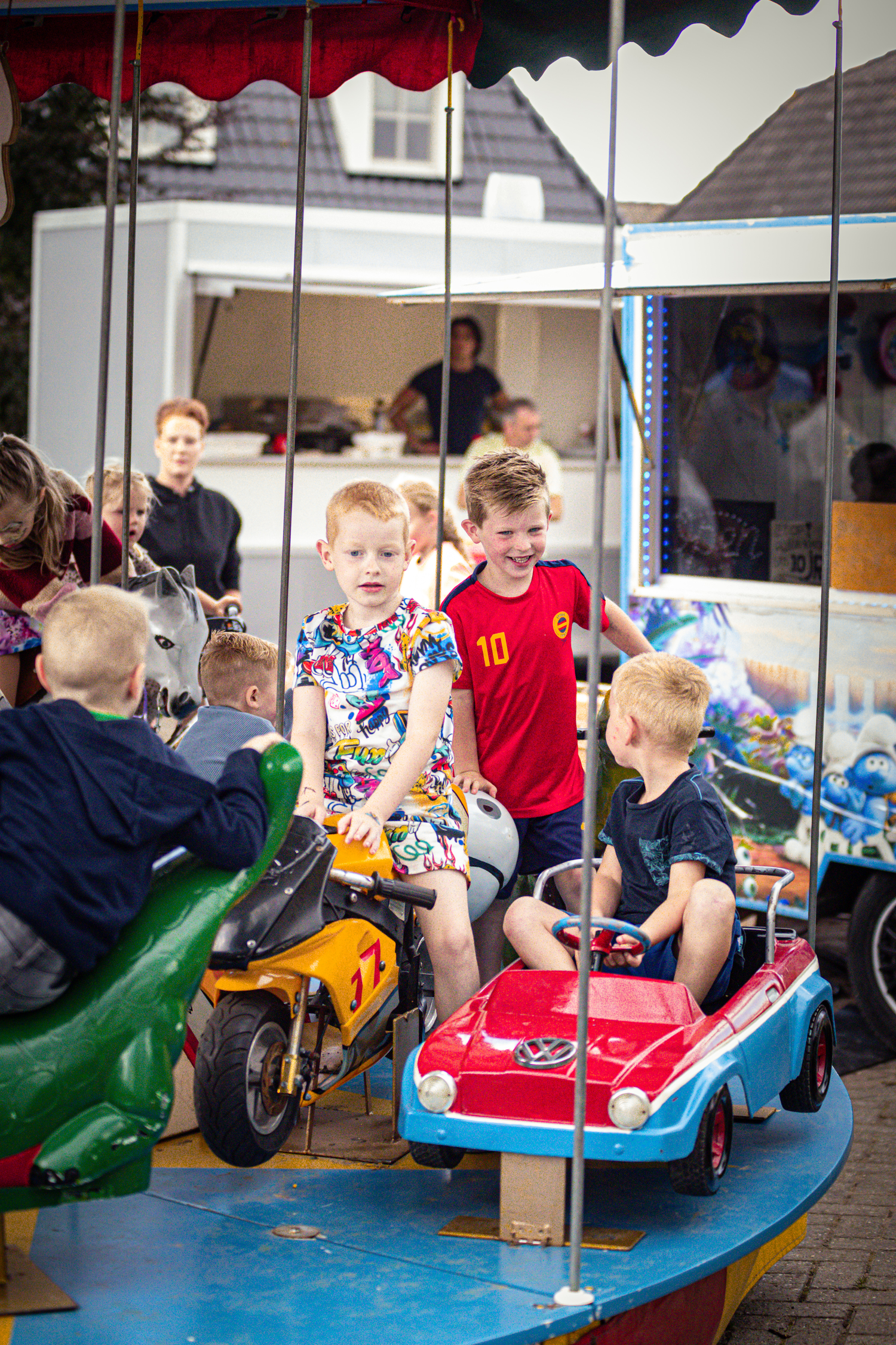 Children are playing with toy vehicles at a carnival game.