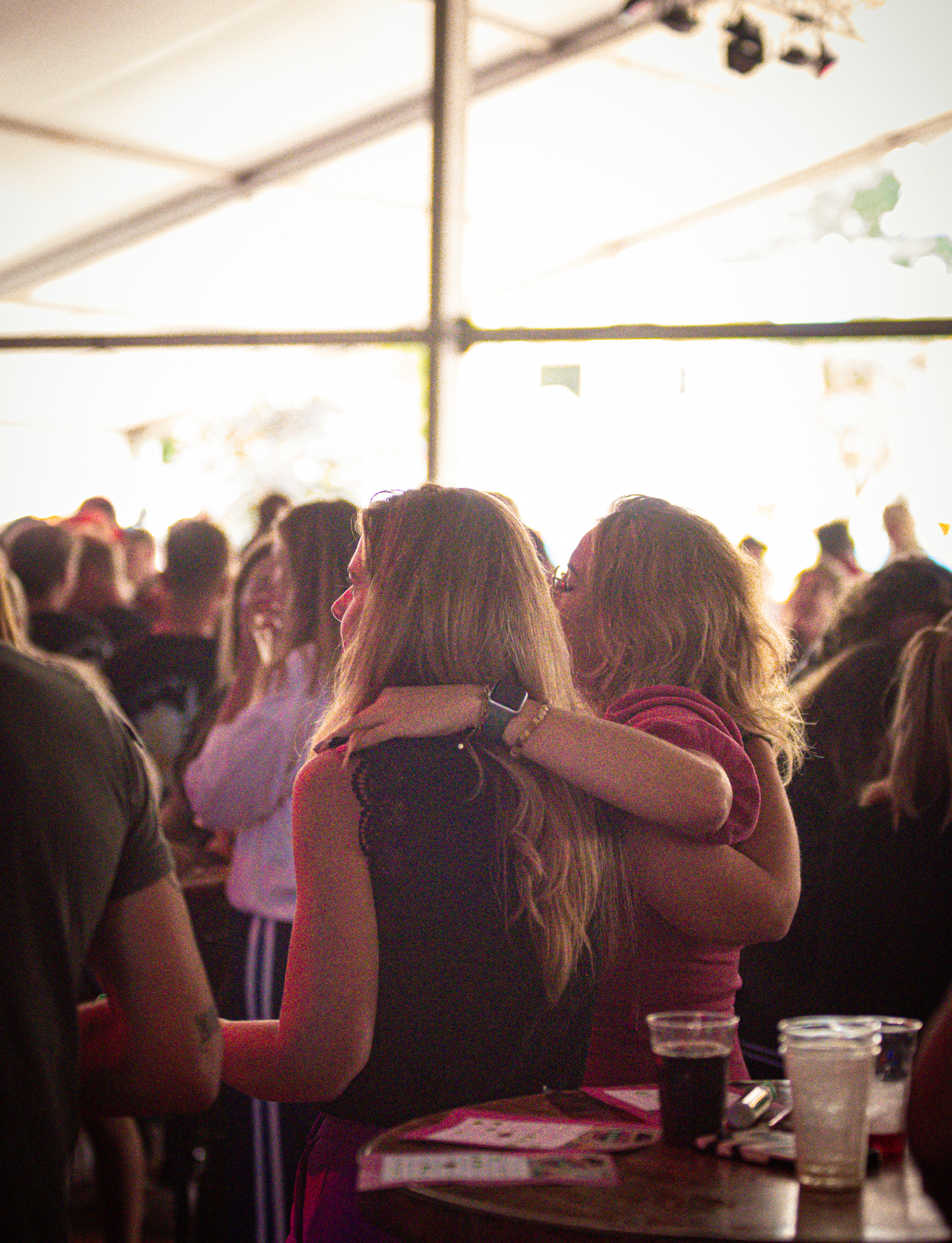 Two women in a crowd, with one wearing red and the other black.