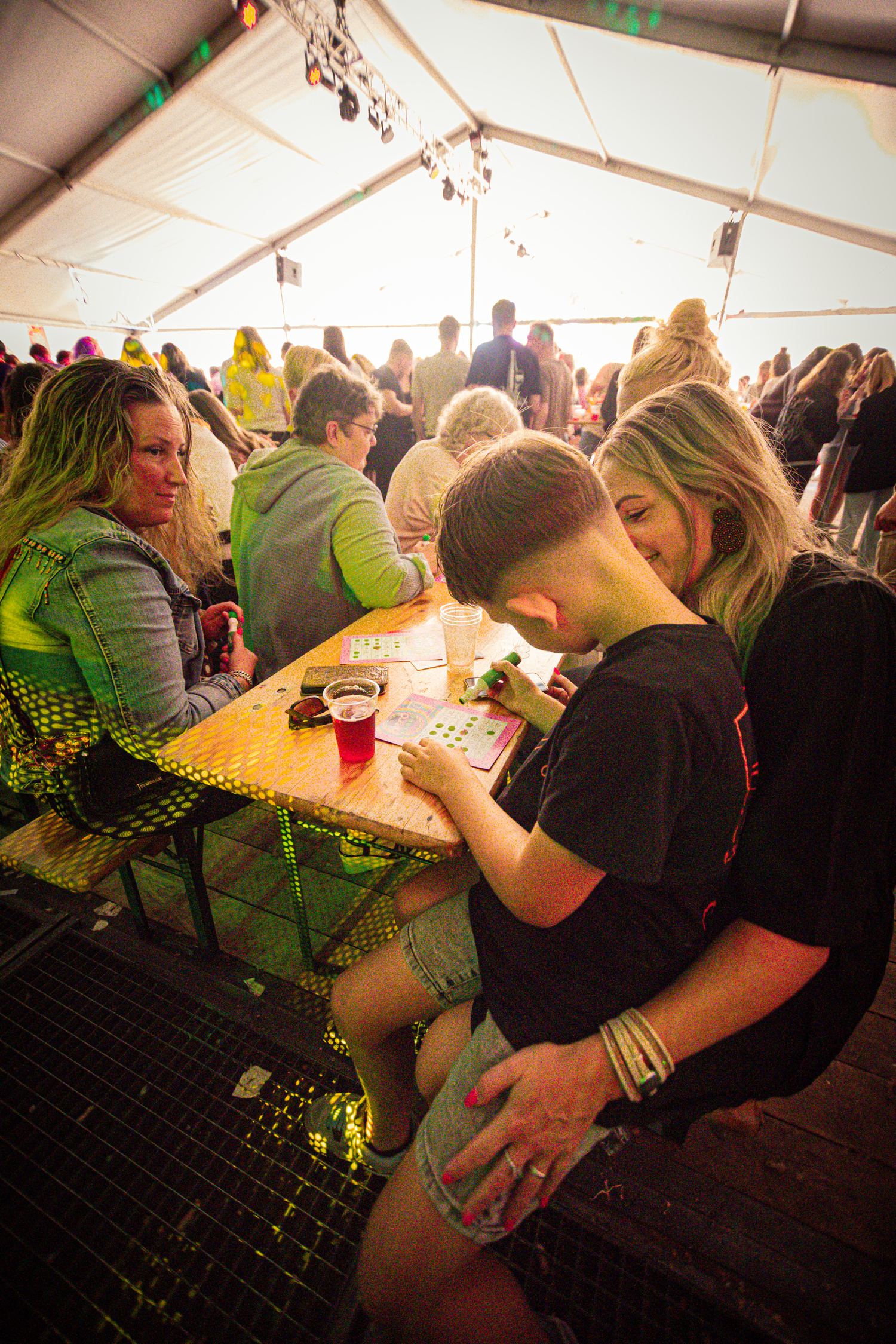 A woman is hugging a young boy who is sitting on her lap at a table.