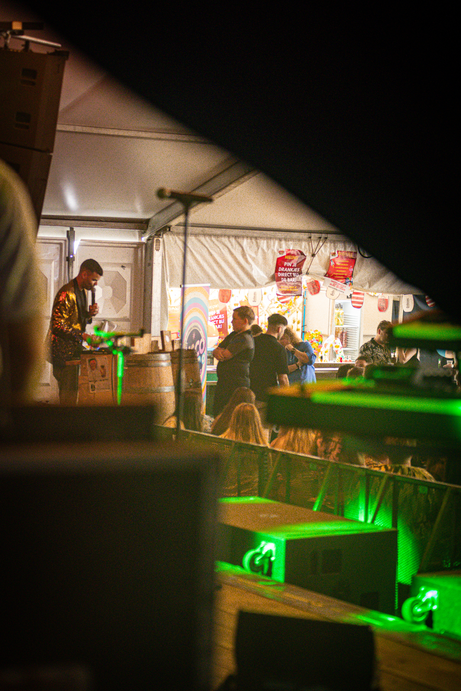 A small bar with a man in a yellow shirt standing behind it.