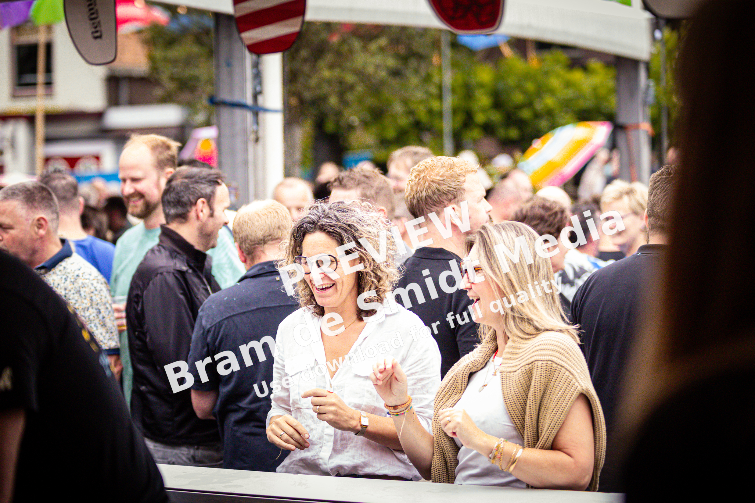 Two women wearing white shirts are smiling at the camera.