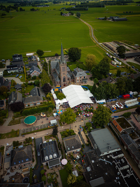 A city square with a green tent set up in the center of it.