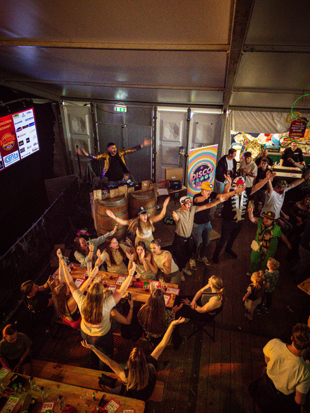 A group of people are celebrating at the Kermis Boerhaar, participating in a fun and lively event with each other.