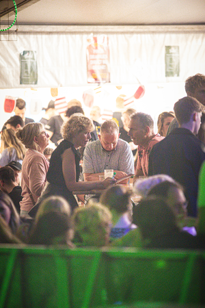 A group of people are gathered at an event, enjoying some food.