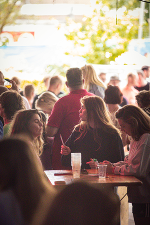 A crowd of people gathered around a table at an outdoor event.