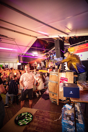 A man wearing a yellow jacket is performing for an audience.