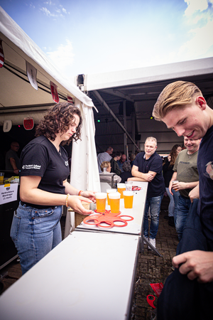 A group of people standing in front of a table filled with drinks.