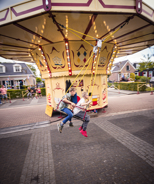 A boy sits in a swing with the words "Middag & avond" painted on it.