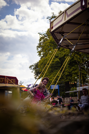 A couple in a carnival ride are enjoying their time together.