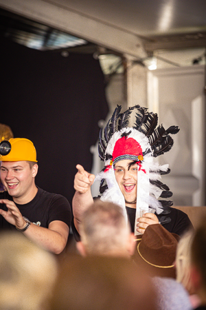 Two young men are wearing Native American costumes at a party.