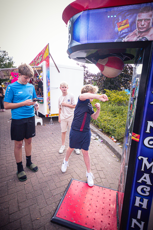 Four people are playing with a boxing machine in the street.