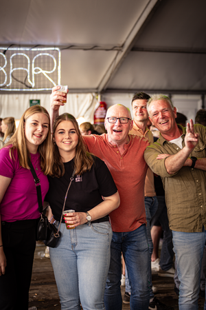 A group of people posing and laughing at a Kermis Boerhaar event.