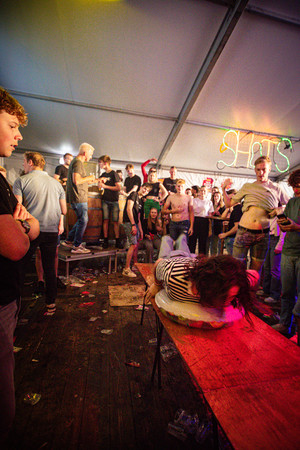 A person is riding a surfboard while others watch at the Kermis Boerhaar event.