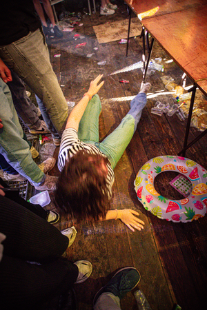 A child is playing on the floor with a colorful beanbag toy.