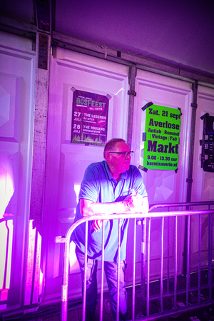 A man sitting next to a sign that says "Kermis Boerhaar".