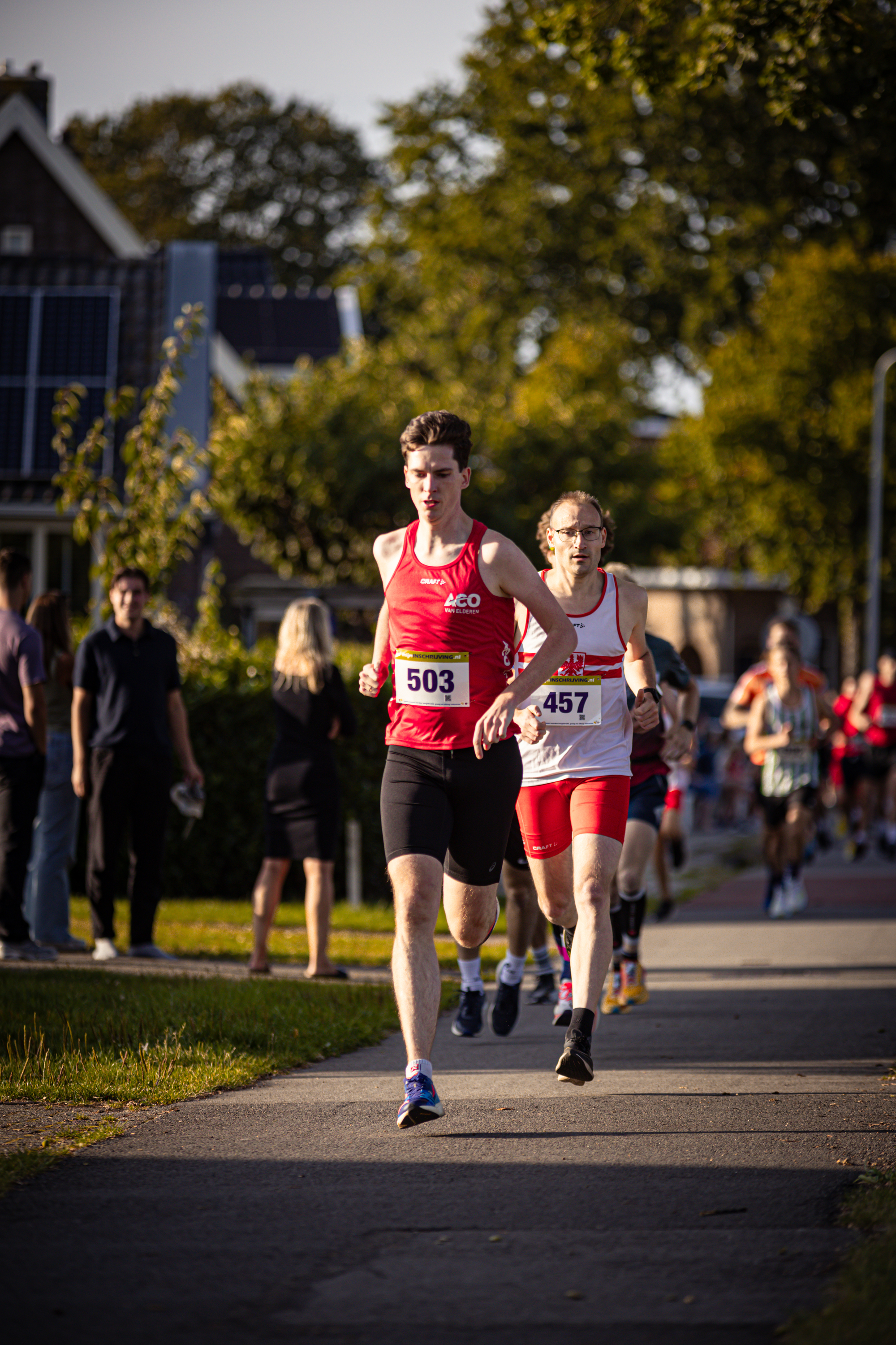 A group of runners are on a path, some wearing bibs with numbers 505 and 4047.