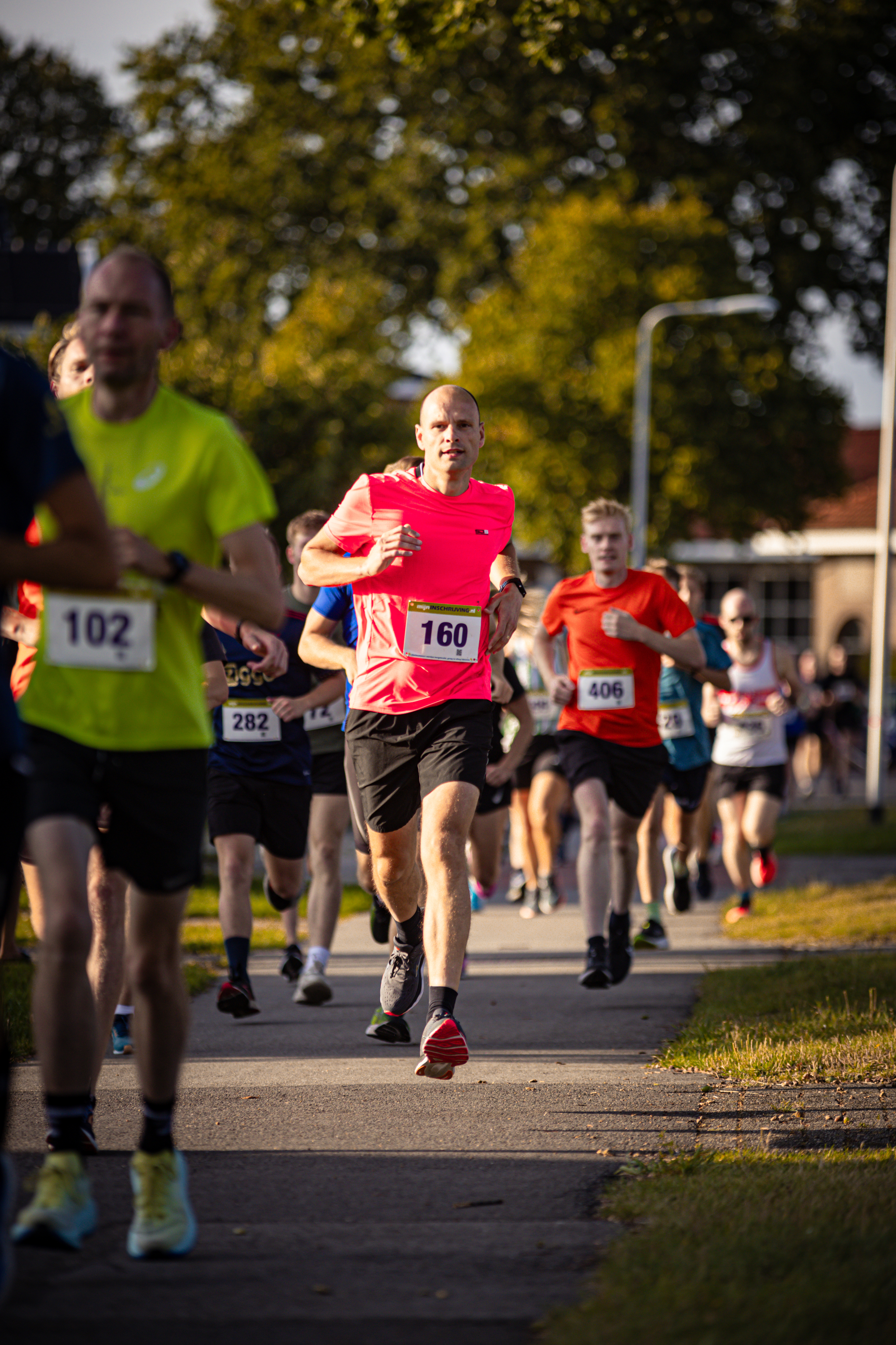 A group of runners in a race. One runner is wearing the number 162 on his shirt.