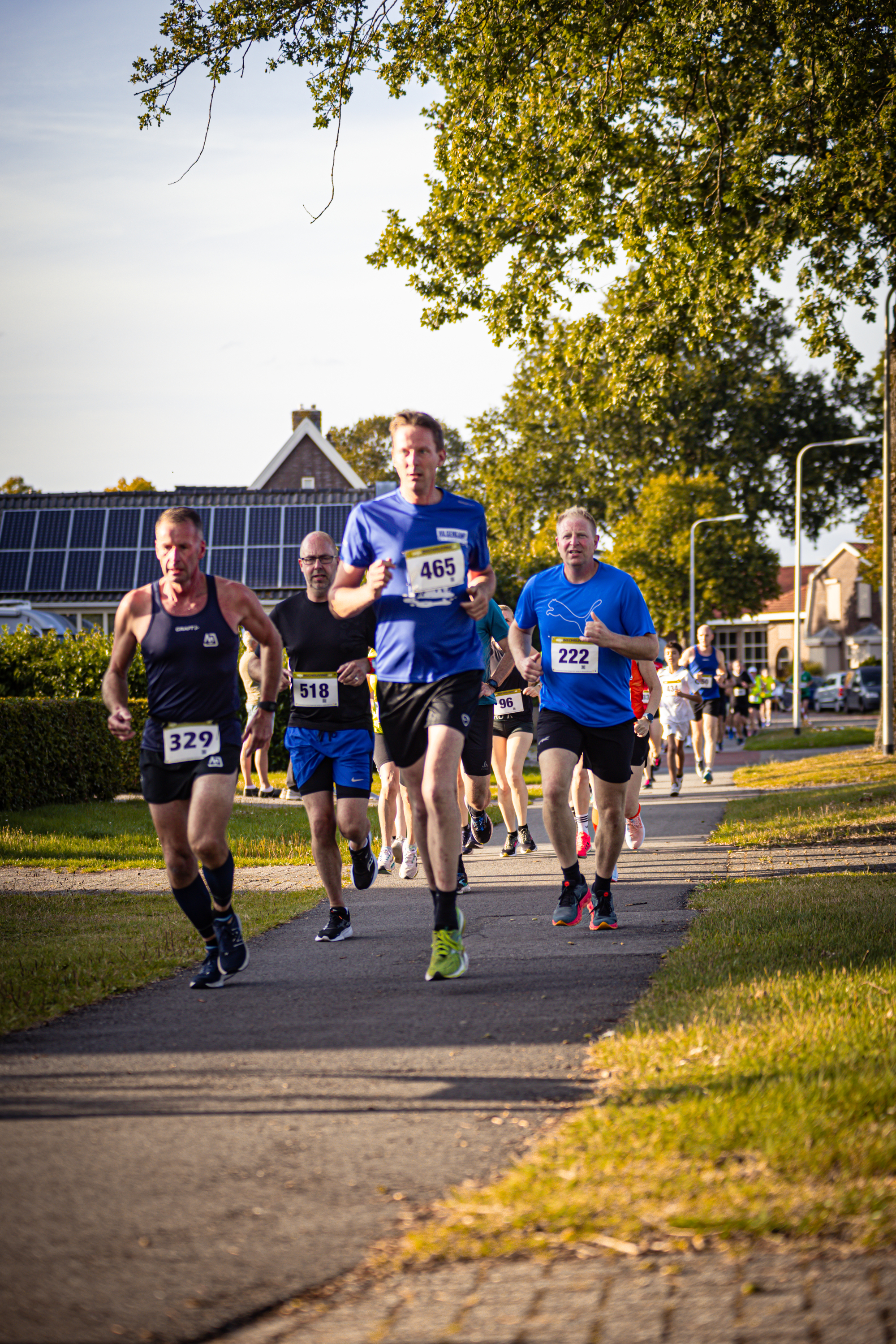 A man running on a sidewalk with the number 37 on his shirt.