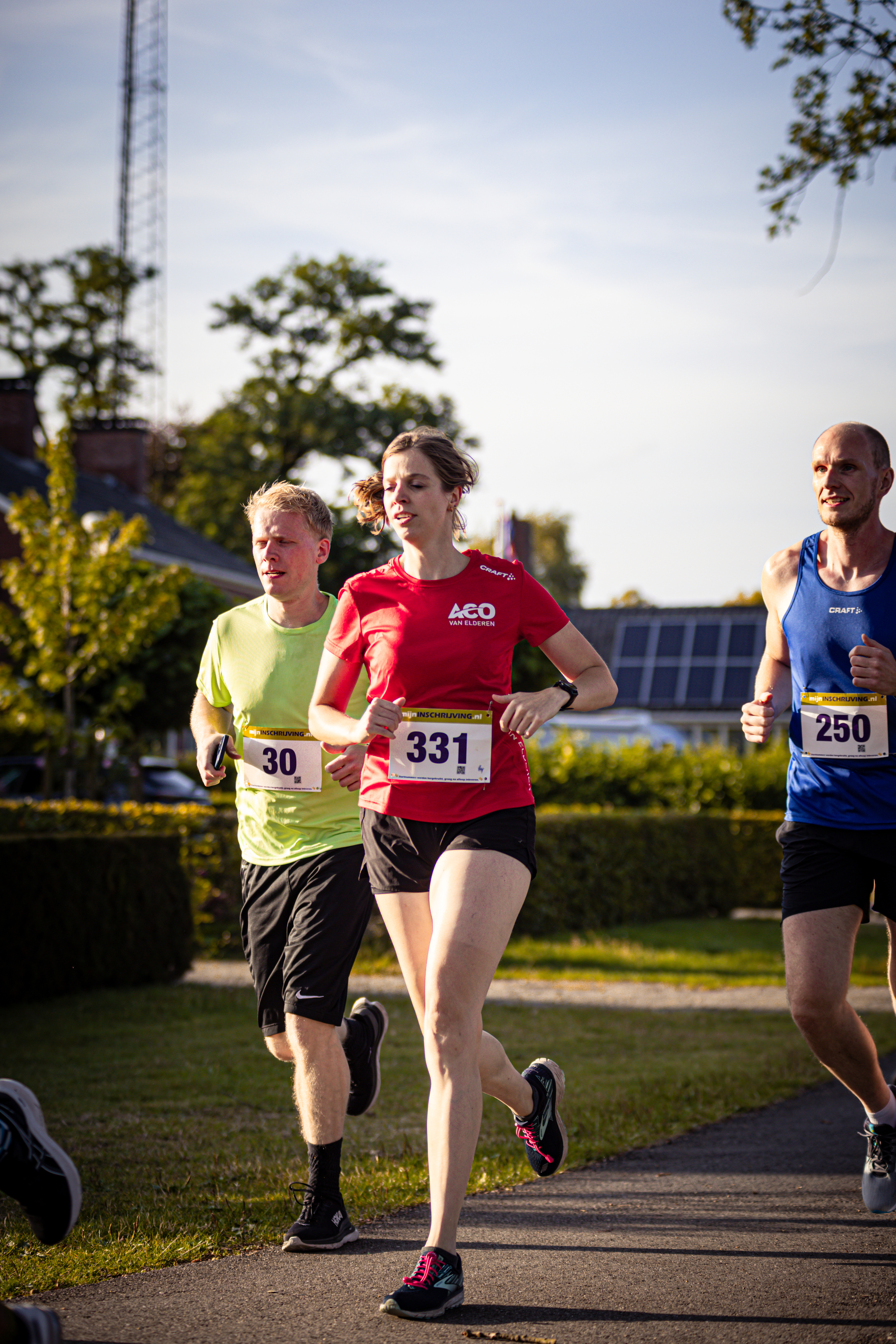 A runner with the number 40 on his shirt runs in a race alongside two other runners.