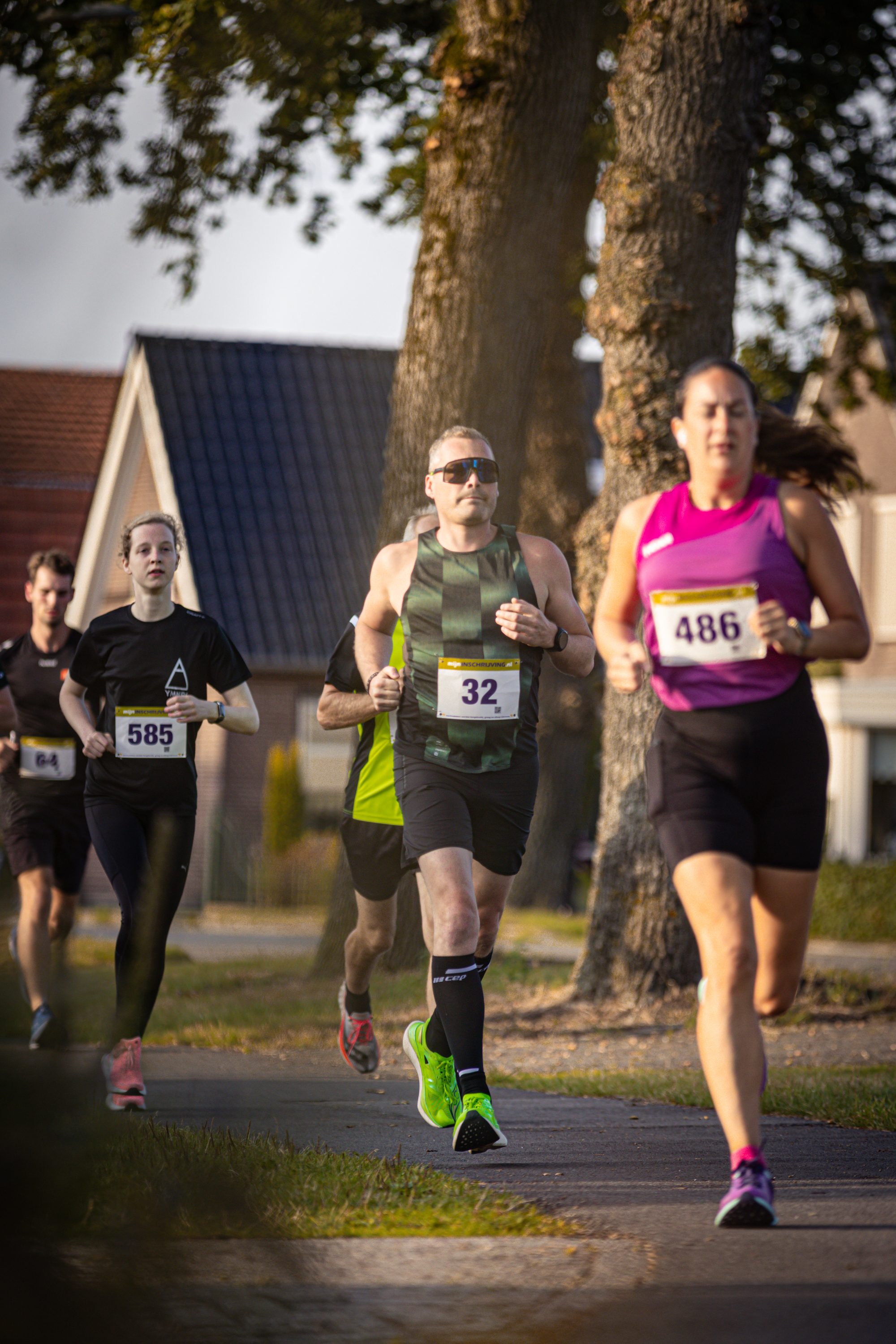 Three runners participating in a race with the numbers 32, 36 and 48 on their shirts.