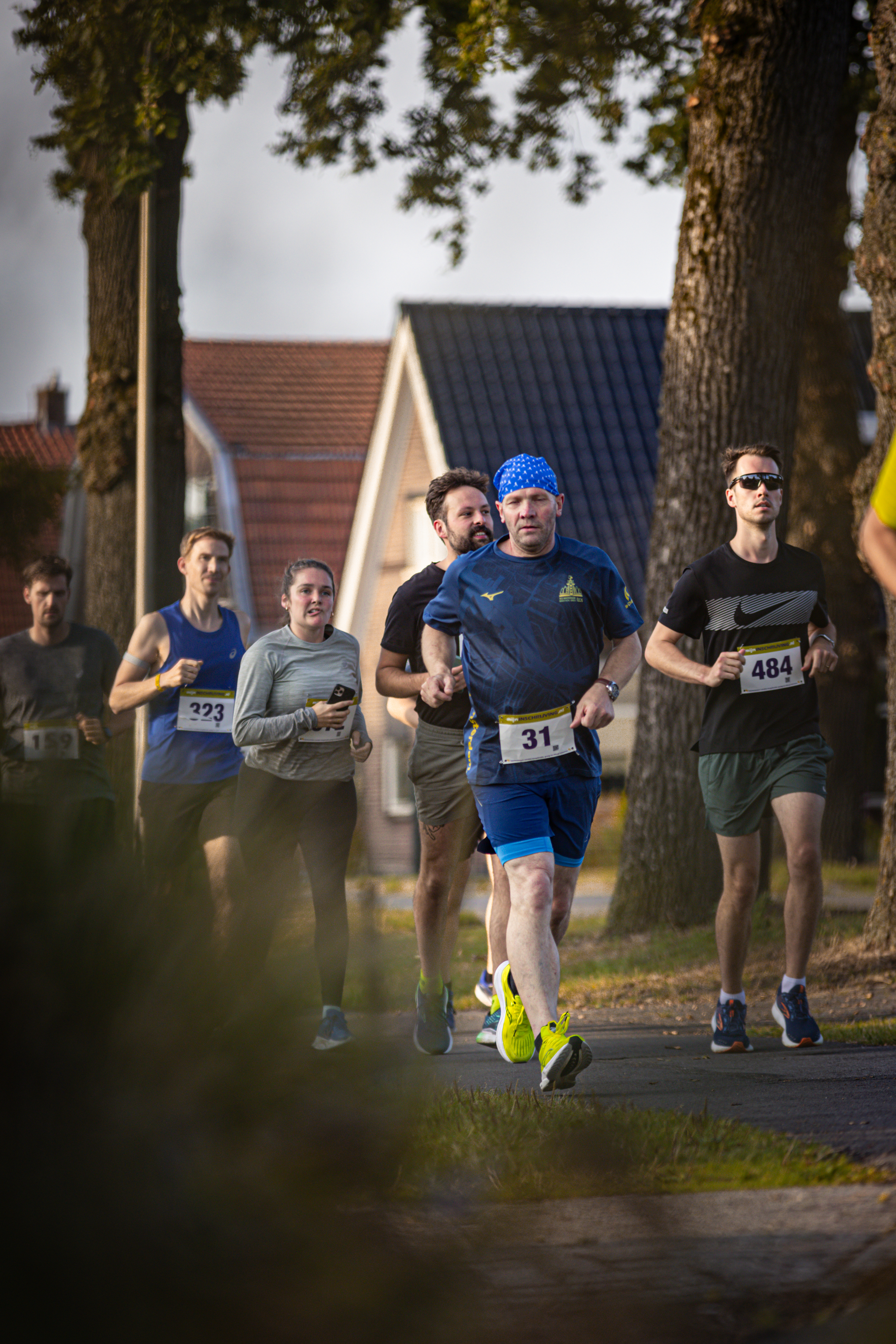 A group of runners participating in a marathon, with bibs numbered 31 and 44.