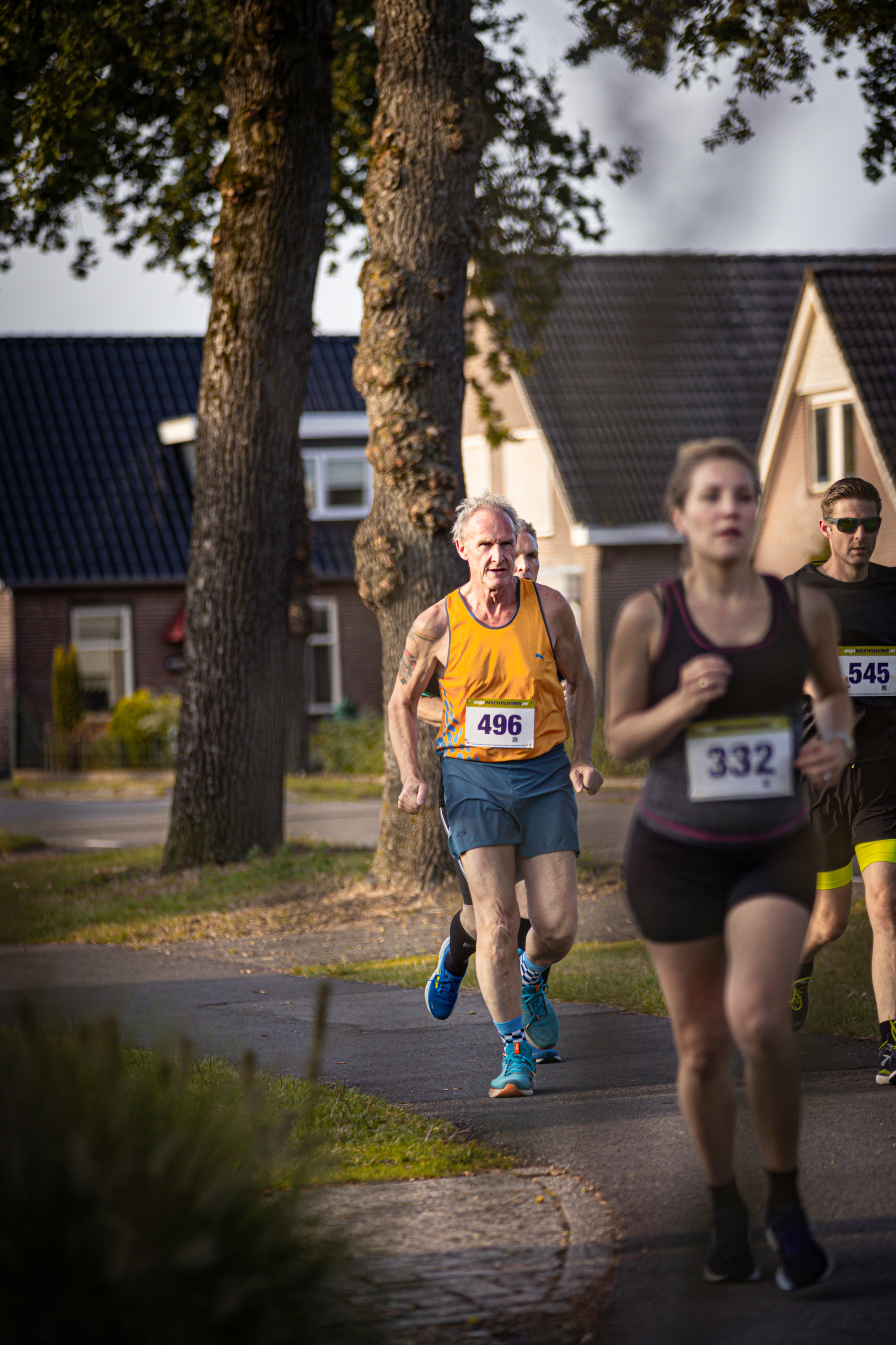 A man in a yellow shirt with number 4019 on it runs down the street.